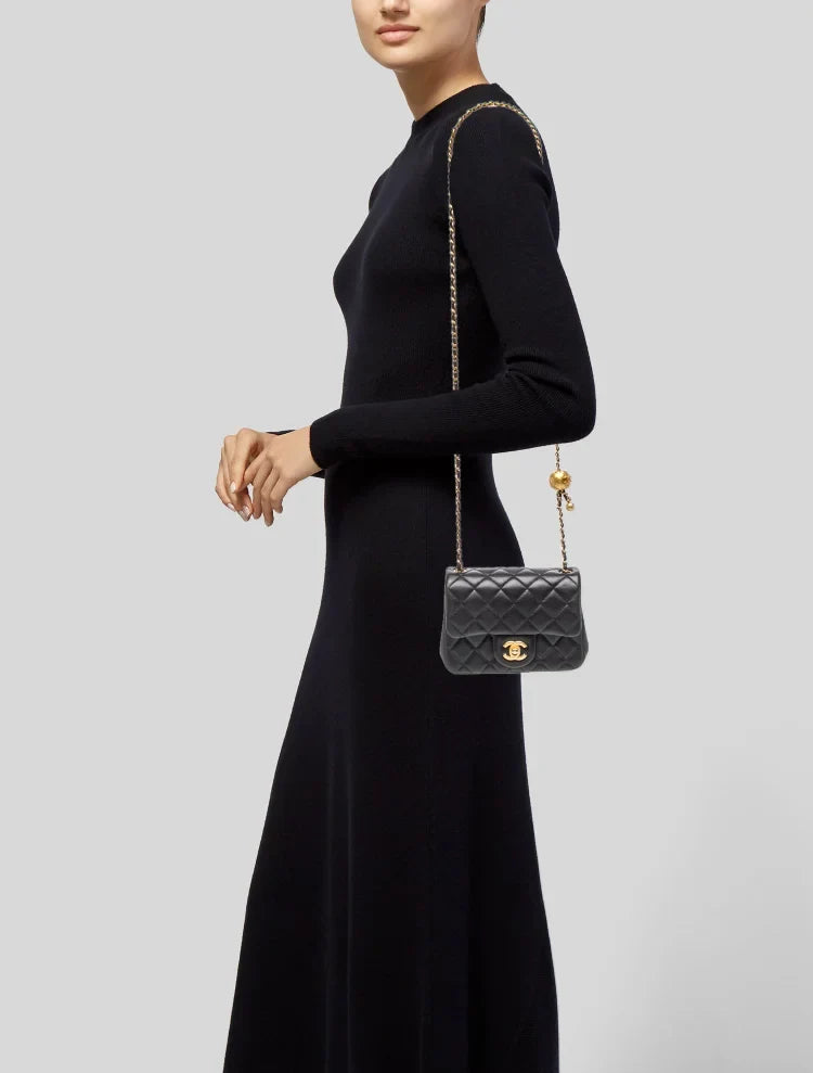 Bolso acolchado negro con cadena gruesa y bolas doradas