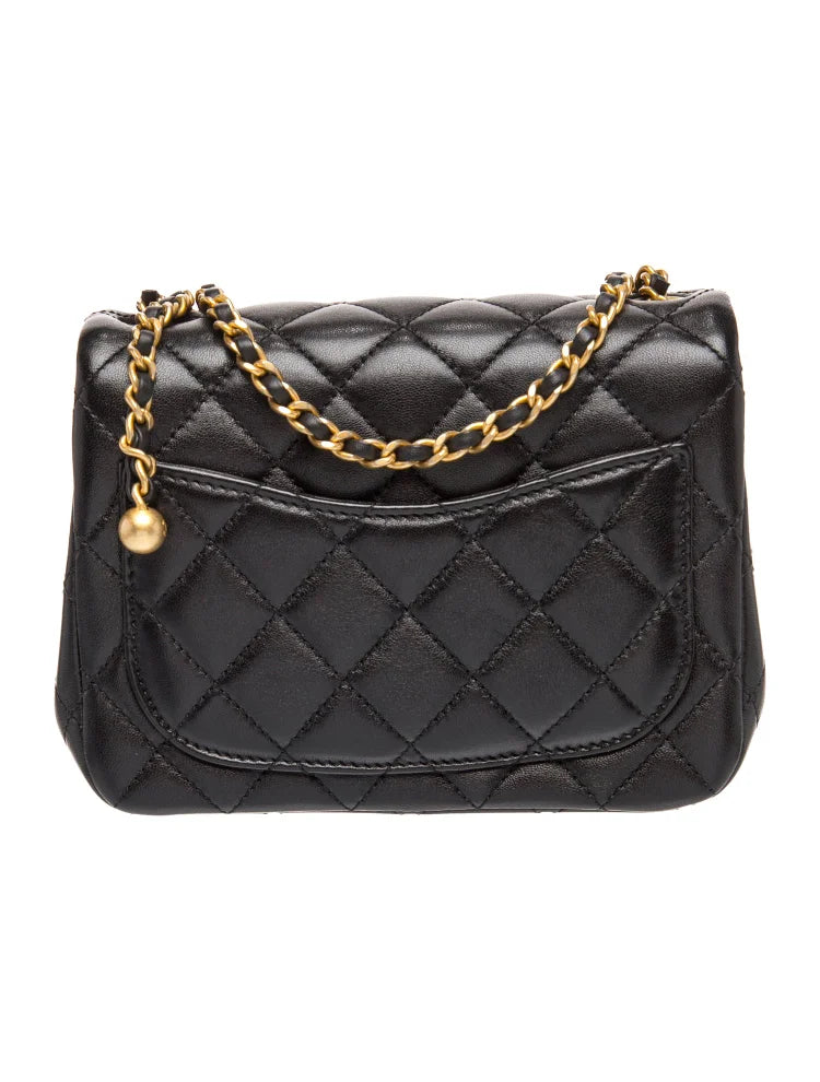 Bolso acolchado negro con cadena gruesa y bolas doradas